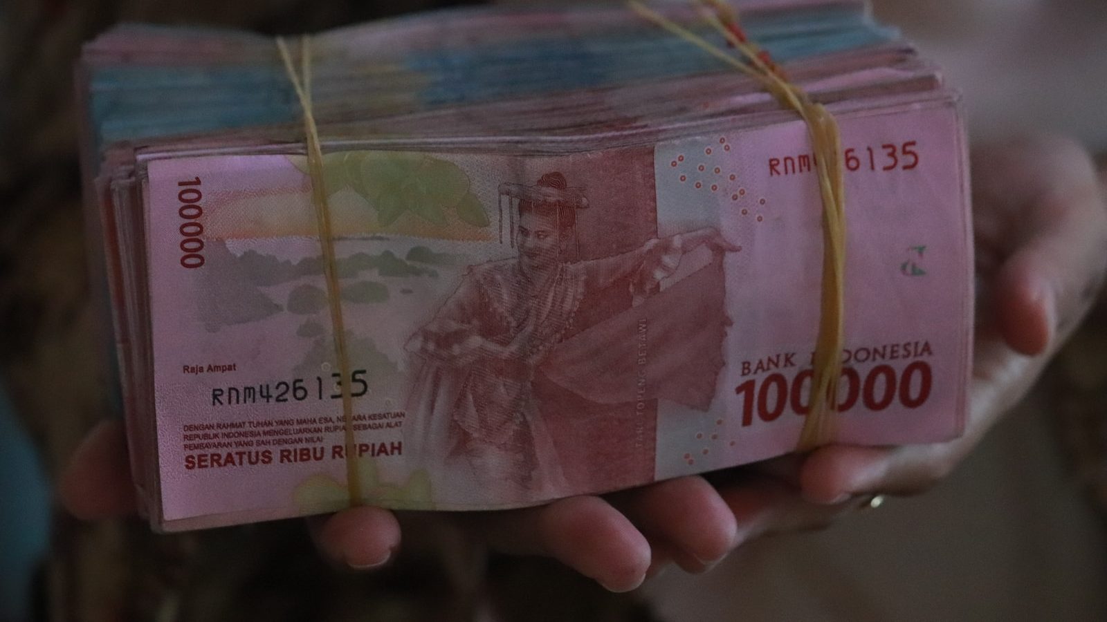 person holding 5000 indonesian rupiah